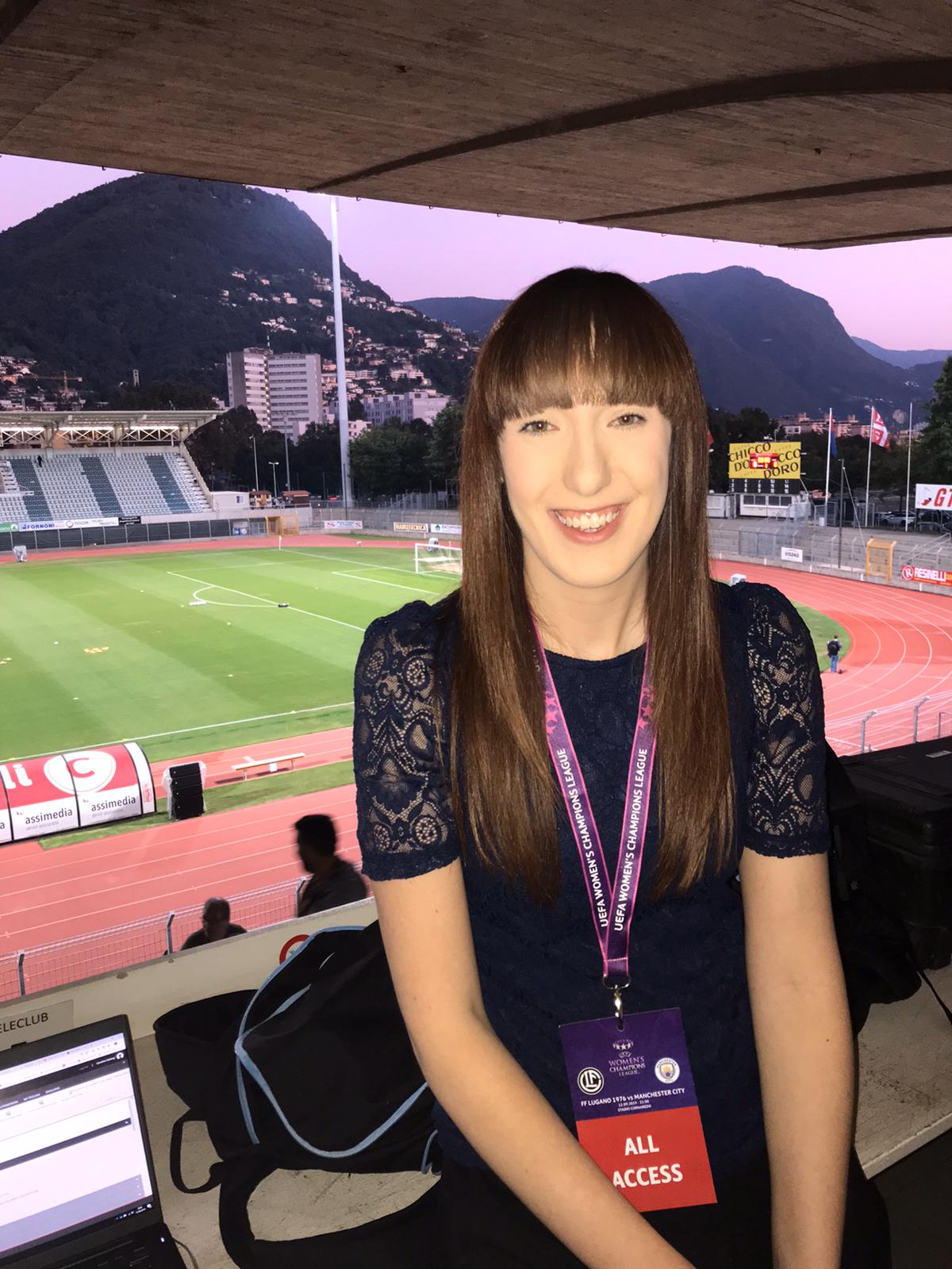 Smiling person in press box in stadium