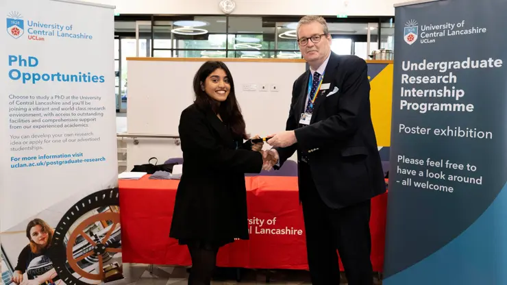 Professor StJohn Crean presenting Kimberly Tellis with an award