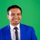 Business and Marketing student Mason Karki wearing blue suit in front of green background