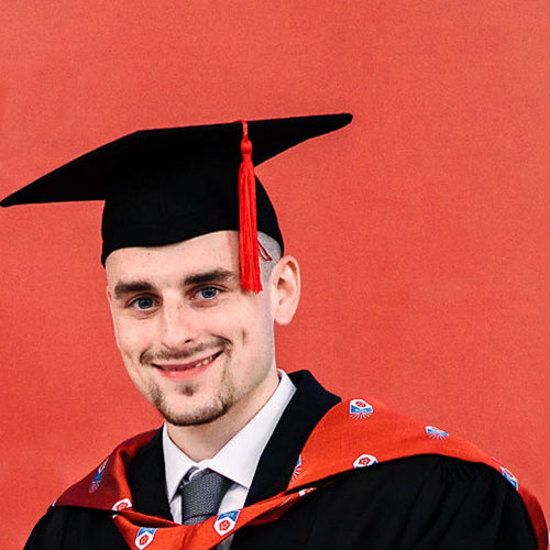 Business student Robert Black in graduation cap and gown