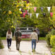 students walking away from camera on a leafy section of campus