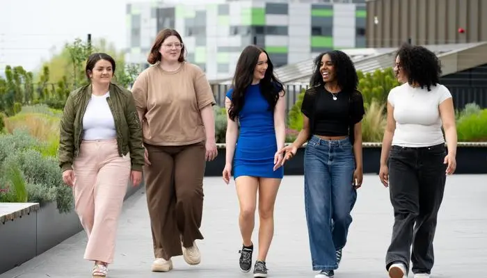 Five students walking and talking on the Student Centre roof.
