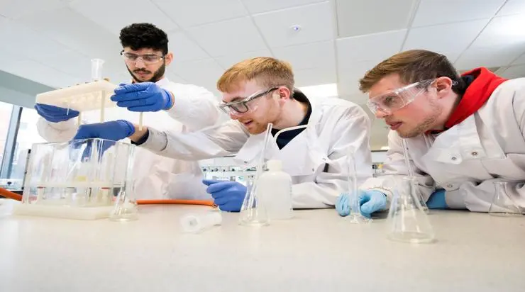 Chemistry students working in a lab in white lab coats