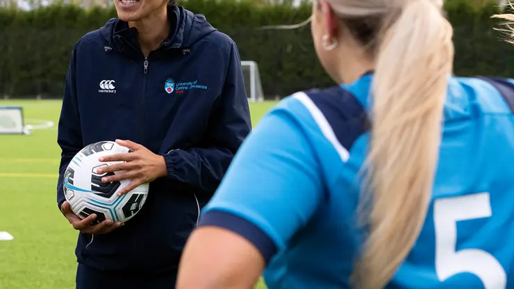 Sports coach talking to a football team.
