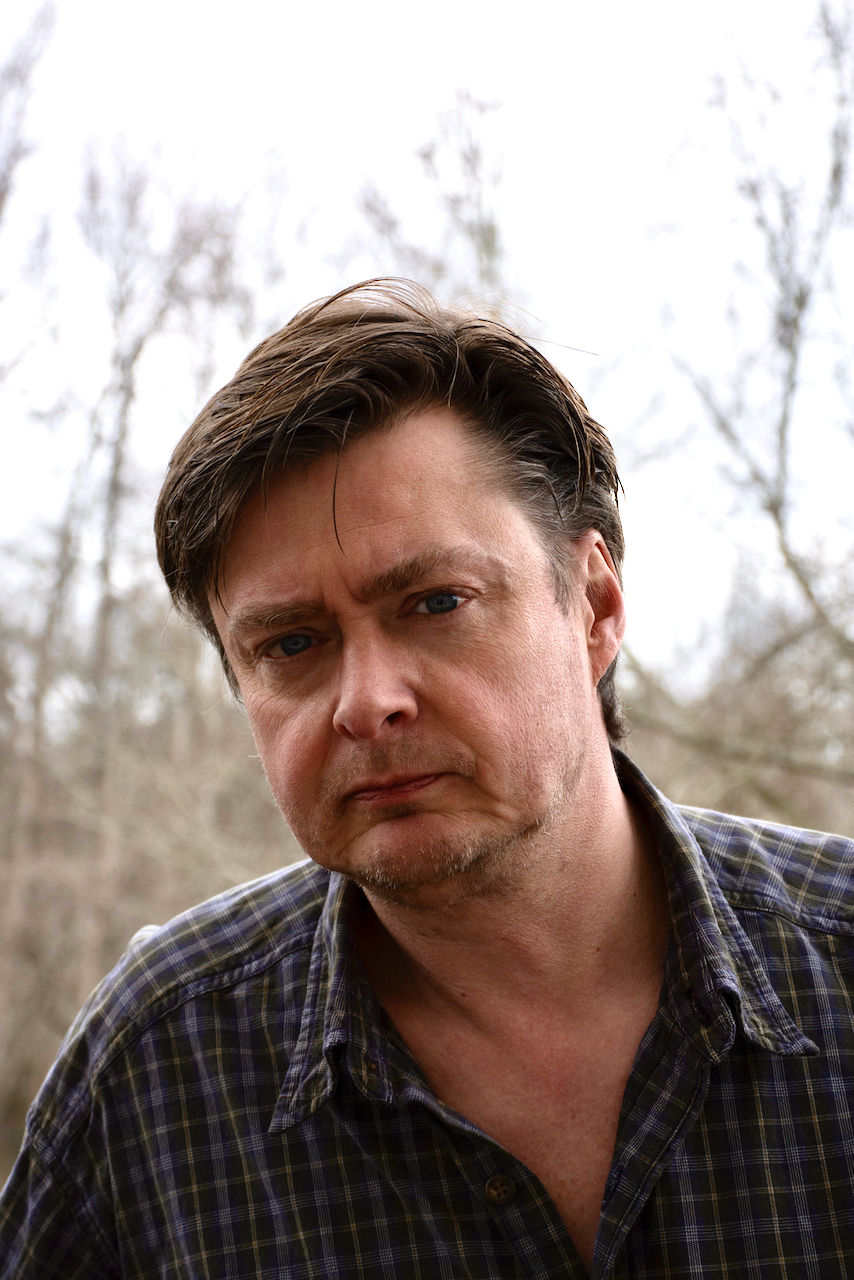 AJ Hartley in a grey and white plaid top outside