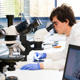 forensic science student looking into a microscope
