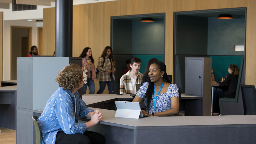 students sat talking at a tablet in the student centre