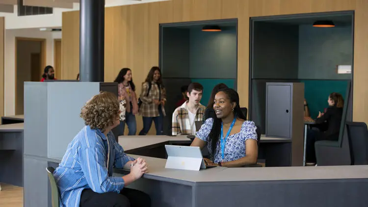 students sat talking at a tablet in the student centre