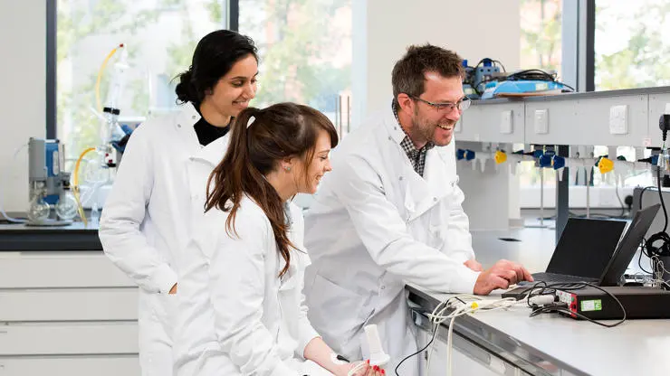 Chemistry staff and students analysing experiment results