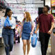 Three students walking through Preston indoor market with shopping bags