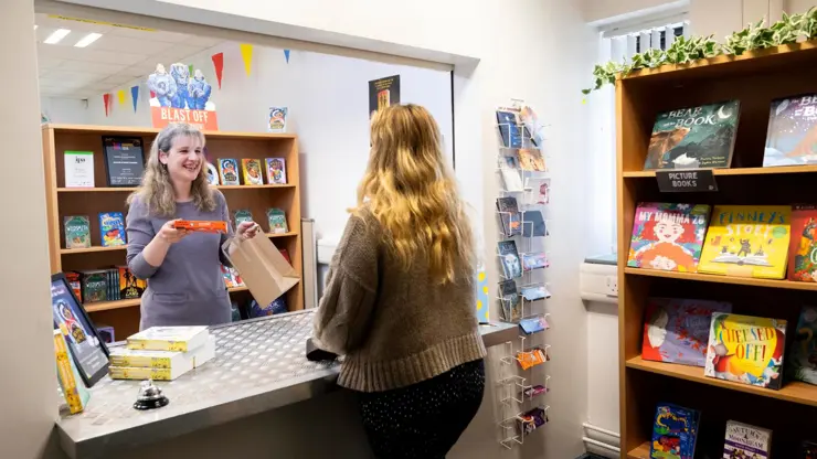 Student buying a book in the UCLan Publishing Bookshop