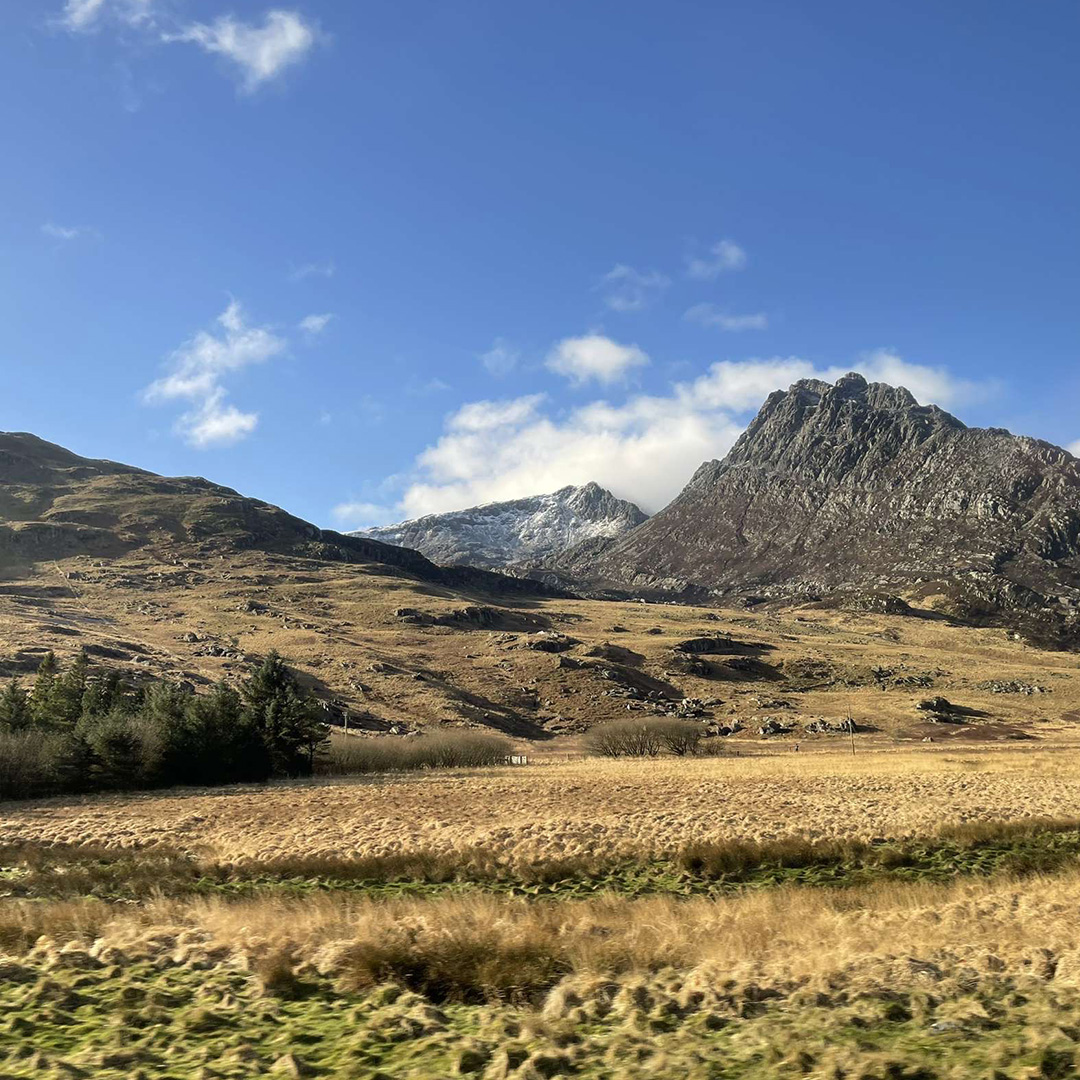 A mountain with clouds behind it