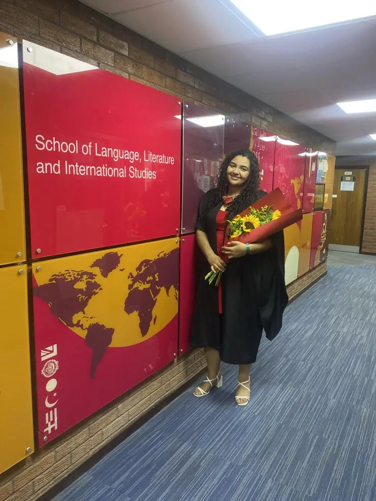 Charlie in the Worldwise Centre wearing her graduation gown