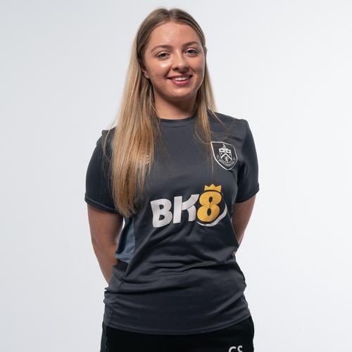 Charlotte Staines with hands behind their back.