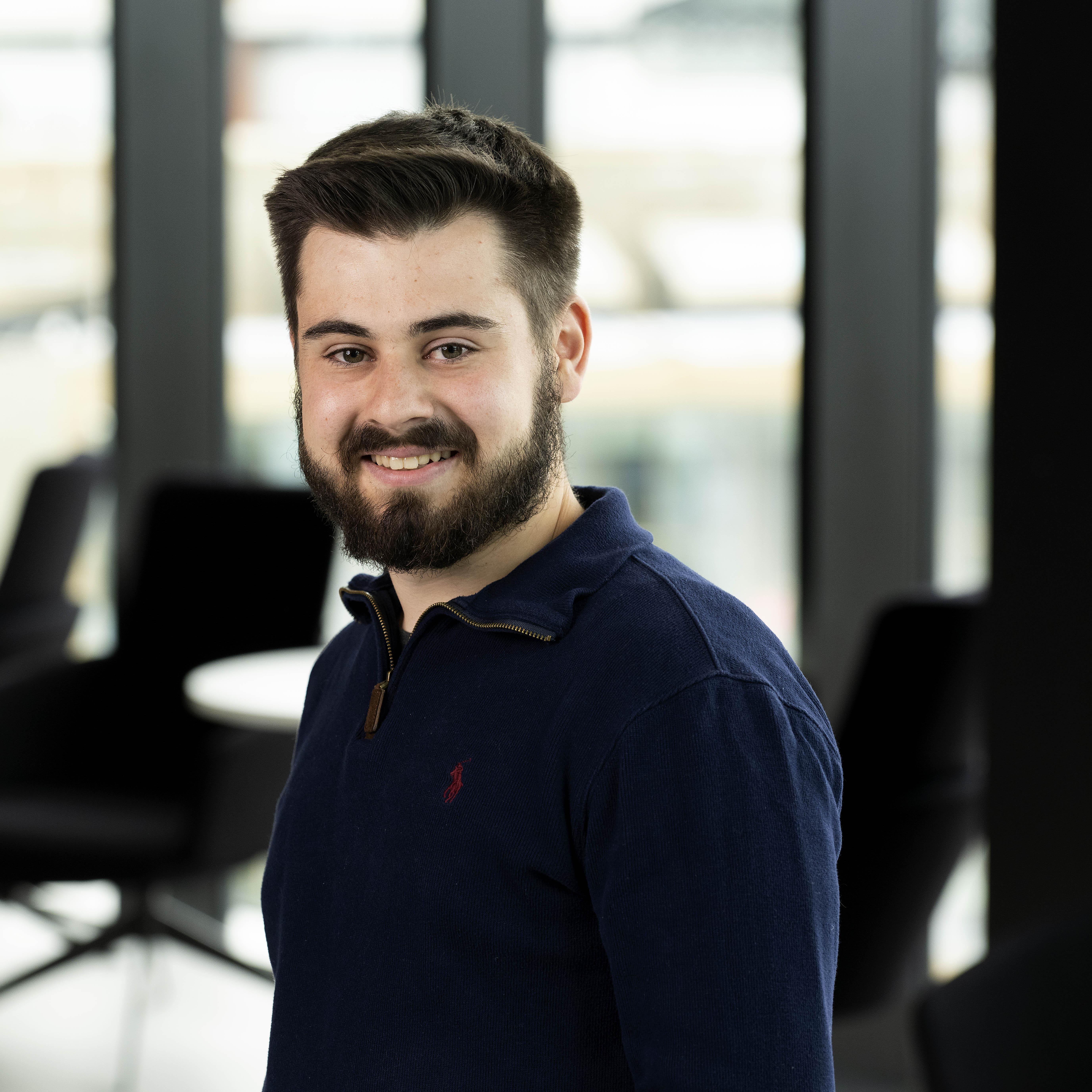 Daniel Earl smiling in a blue jumper