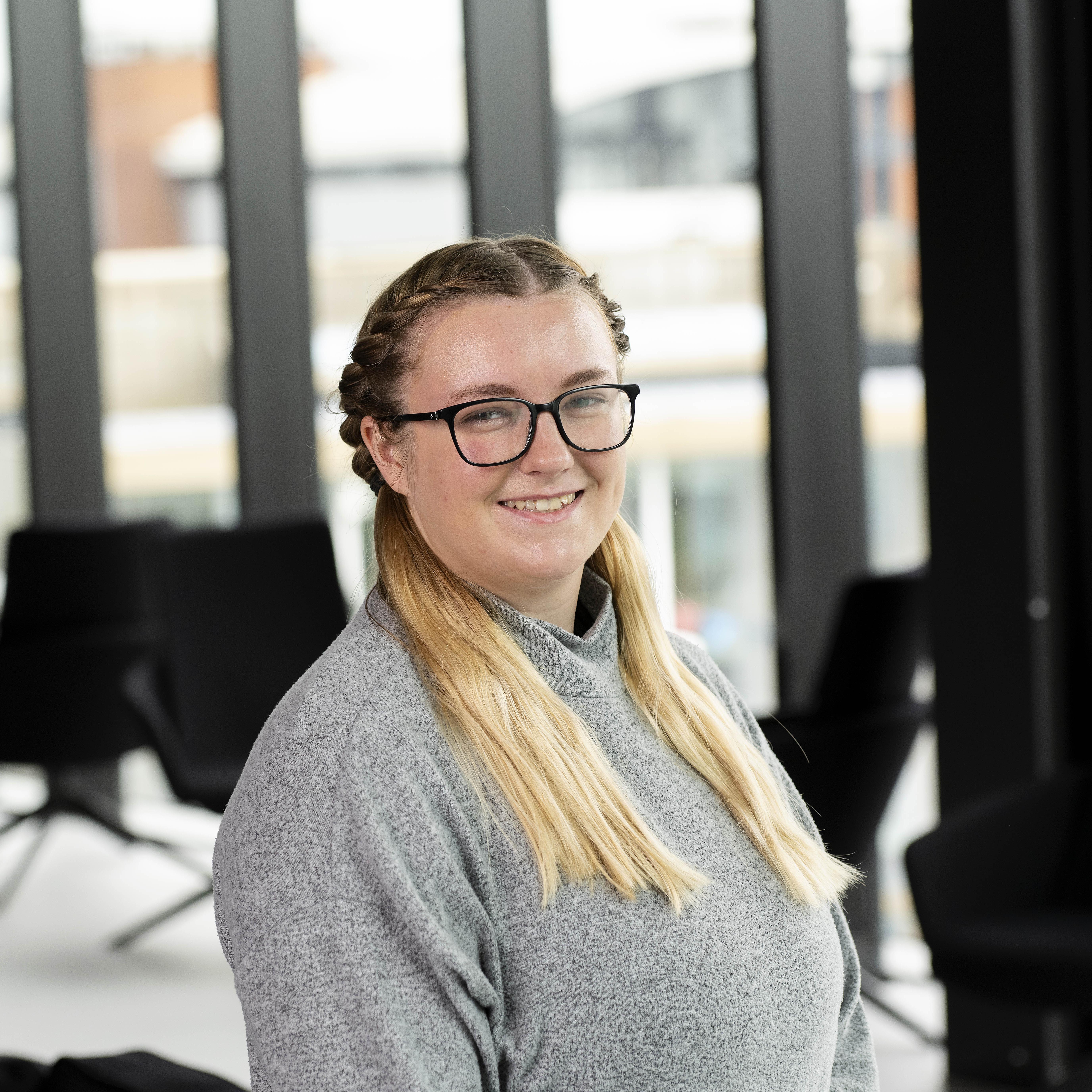 Georgia Green smiling in glasses and a grey jumper