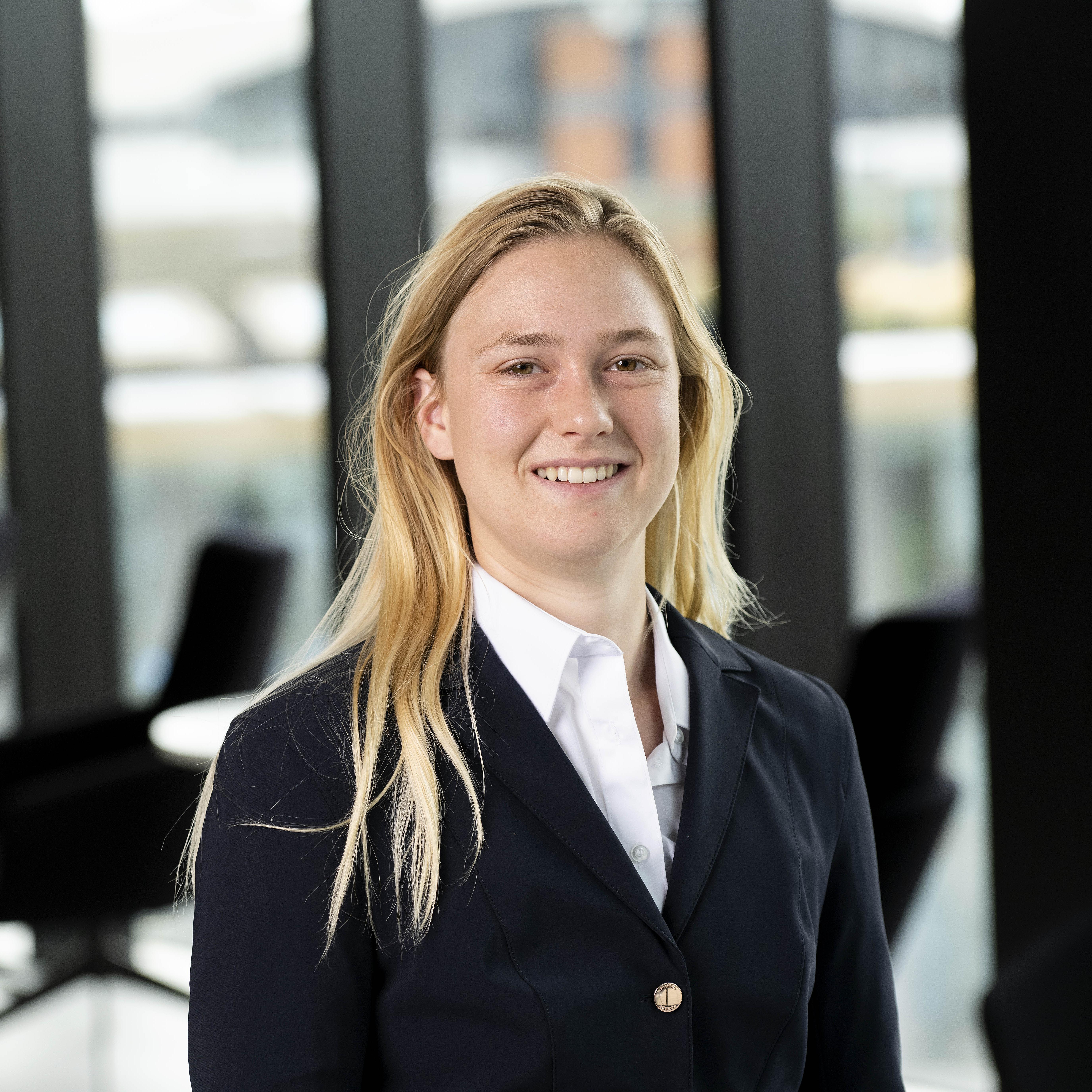 Nyah in a white shirt and black blazer smiling