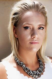 Abbie Stock in a white shirt and beaded necklace