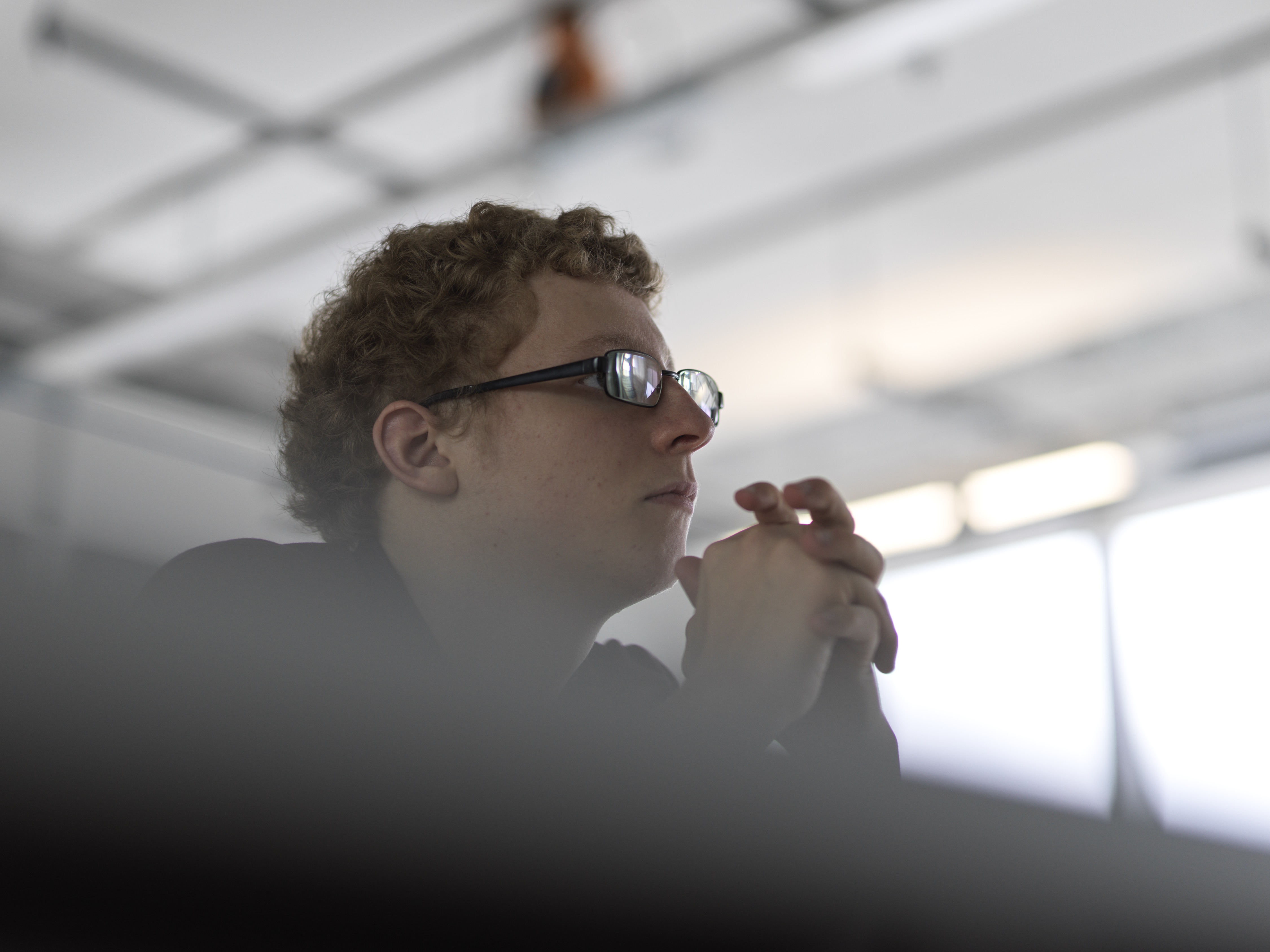 Alex Kerr with glasses and hands together