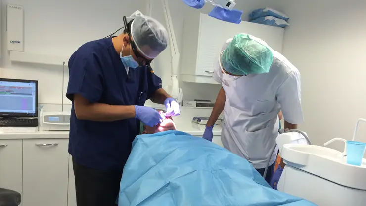 Dental mentoring session. a mentor and student perform dental surgery on a patient