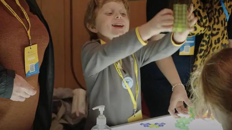 small child at lancashire science festival holding scientific toy in air