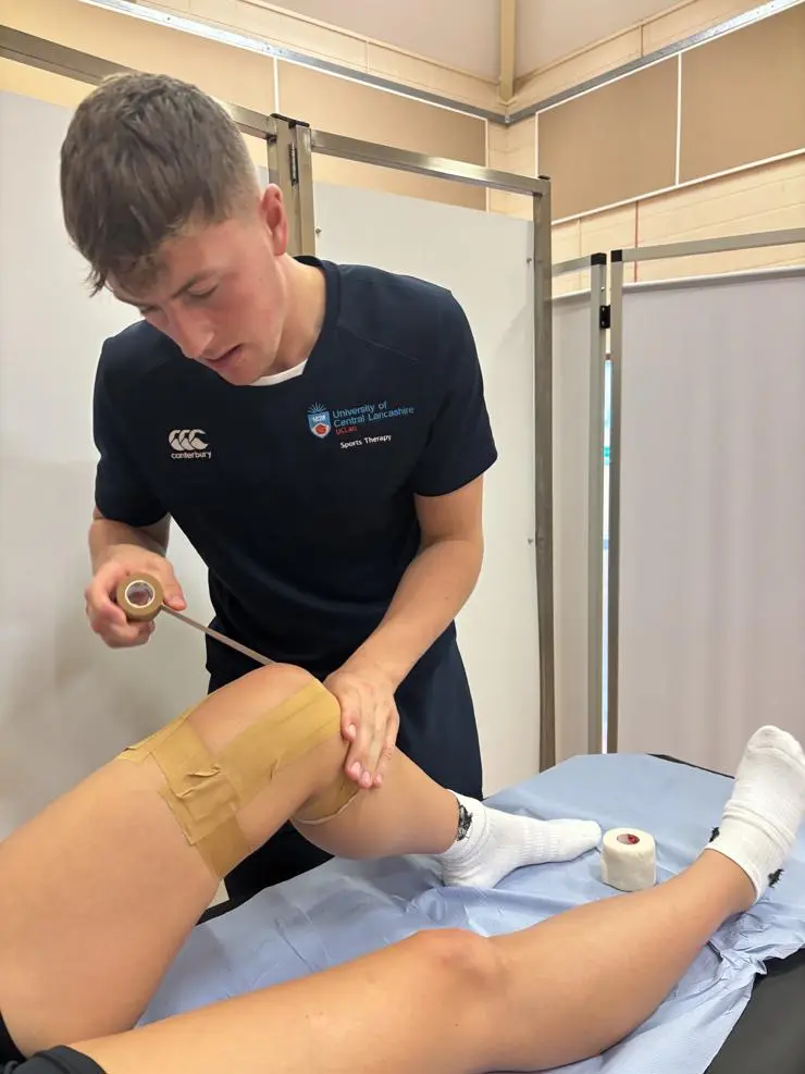  A sports therapy student supporting an athlete