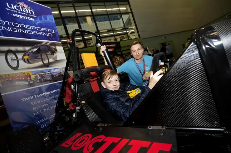 Lucas Riley sitting in the driver's seat and watched by Dominik Luczak