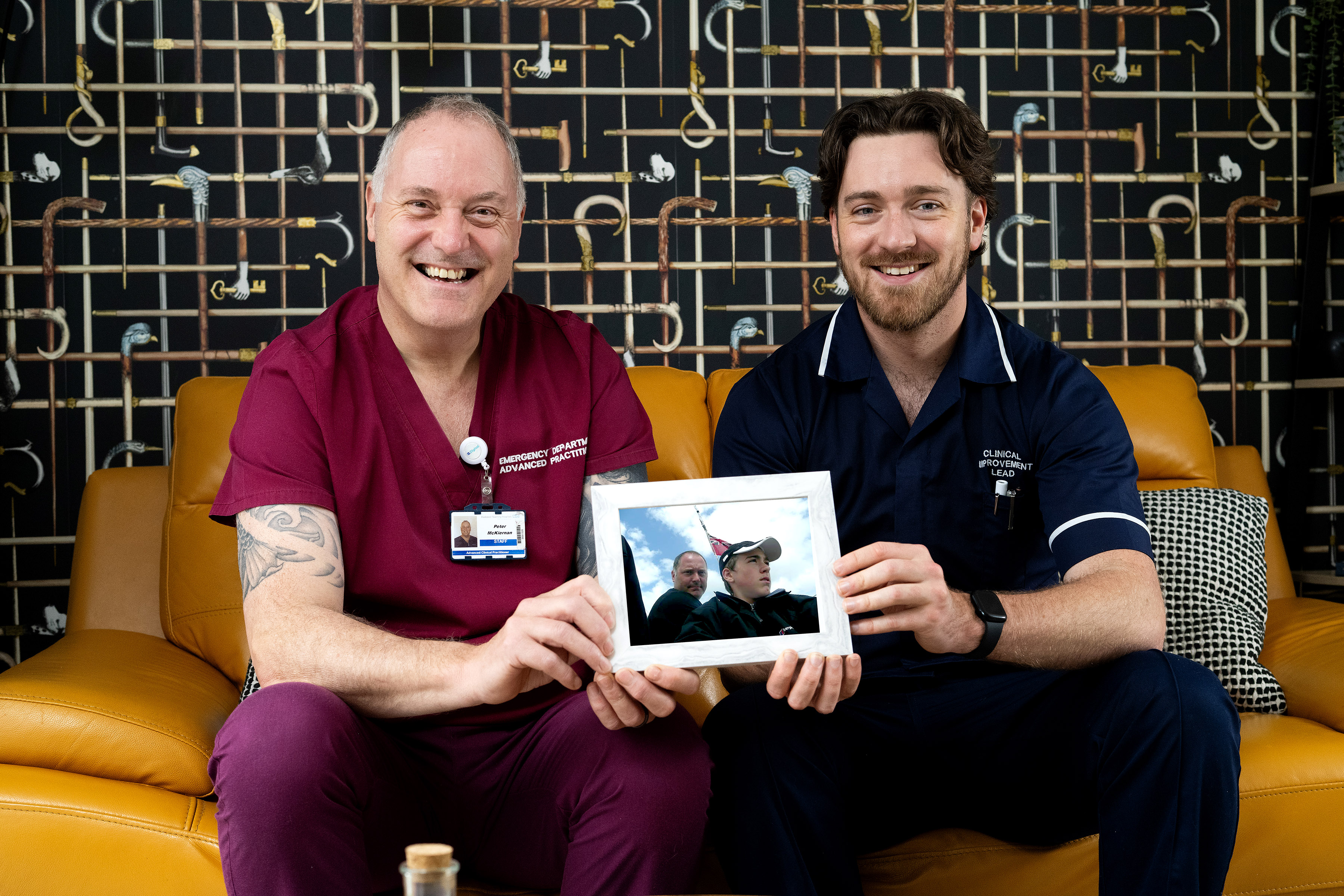 Peter and Connor McKiernan sat in their living room holding a photo of both of them from when Connor was a child
