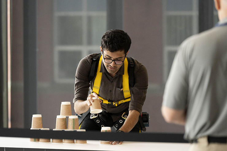 A student from Clemson University, South Carolina, stacks cups to test his agility skills whilst wearing his exoskeleton.