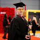 Ben Constable dressed in academic cap and gown and holding a scroll