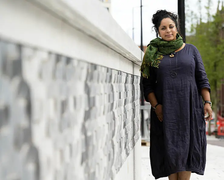 Halima next to the sculptured wall inspired by Lancashire’s cotton mill heritage.