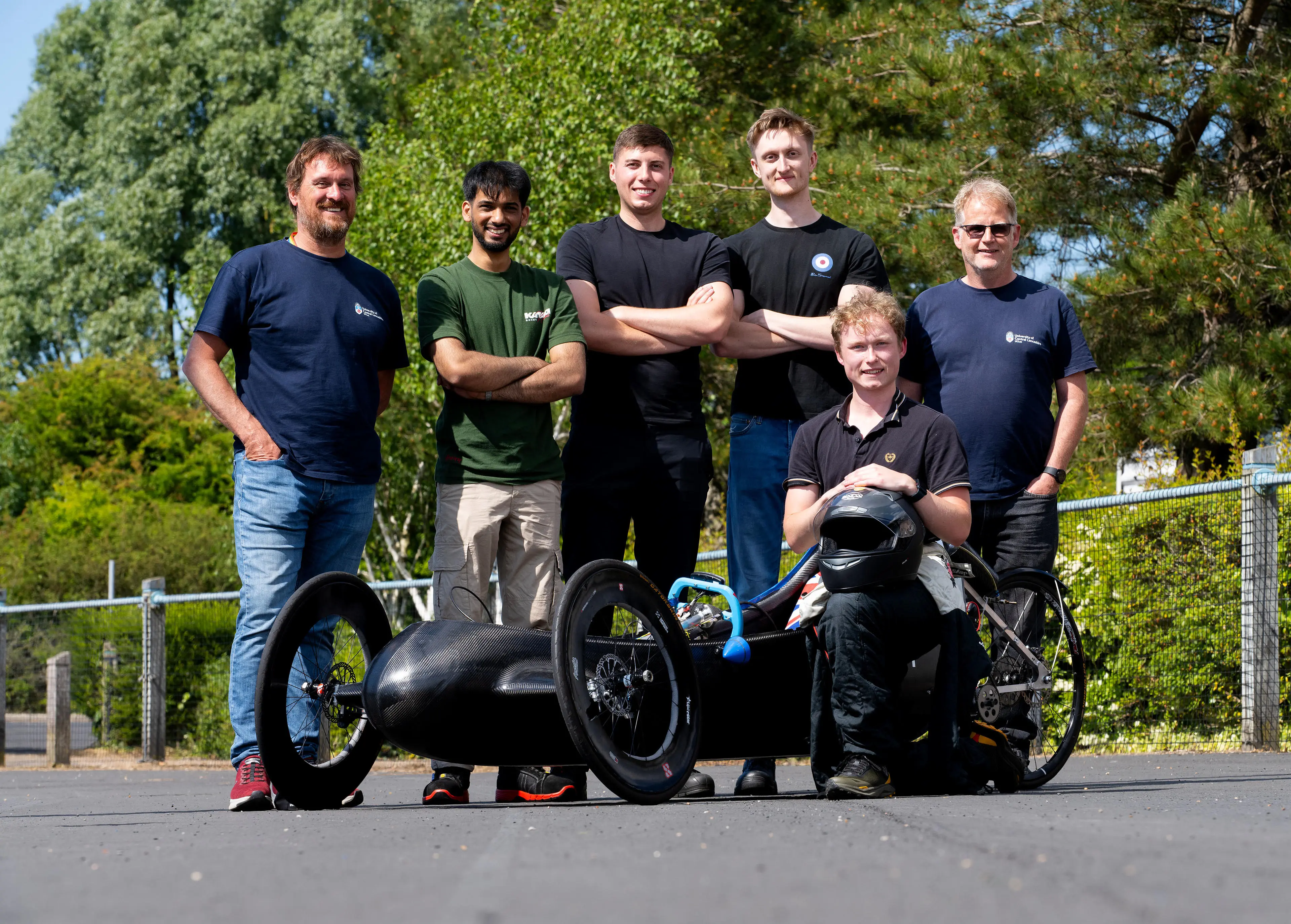 Six men stood around a racing car