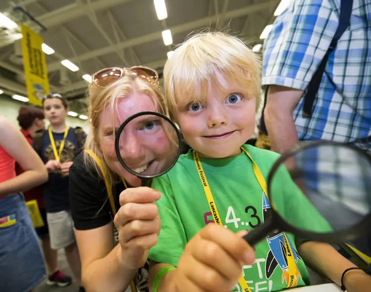 A mum and her young son looking through magnifying glasses