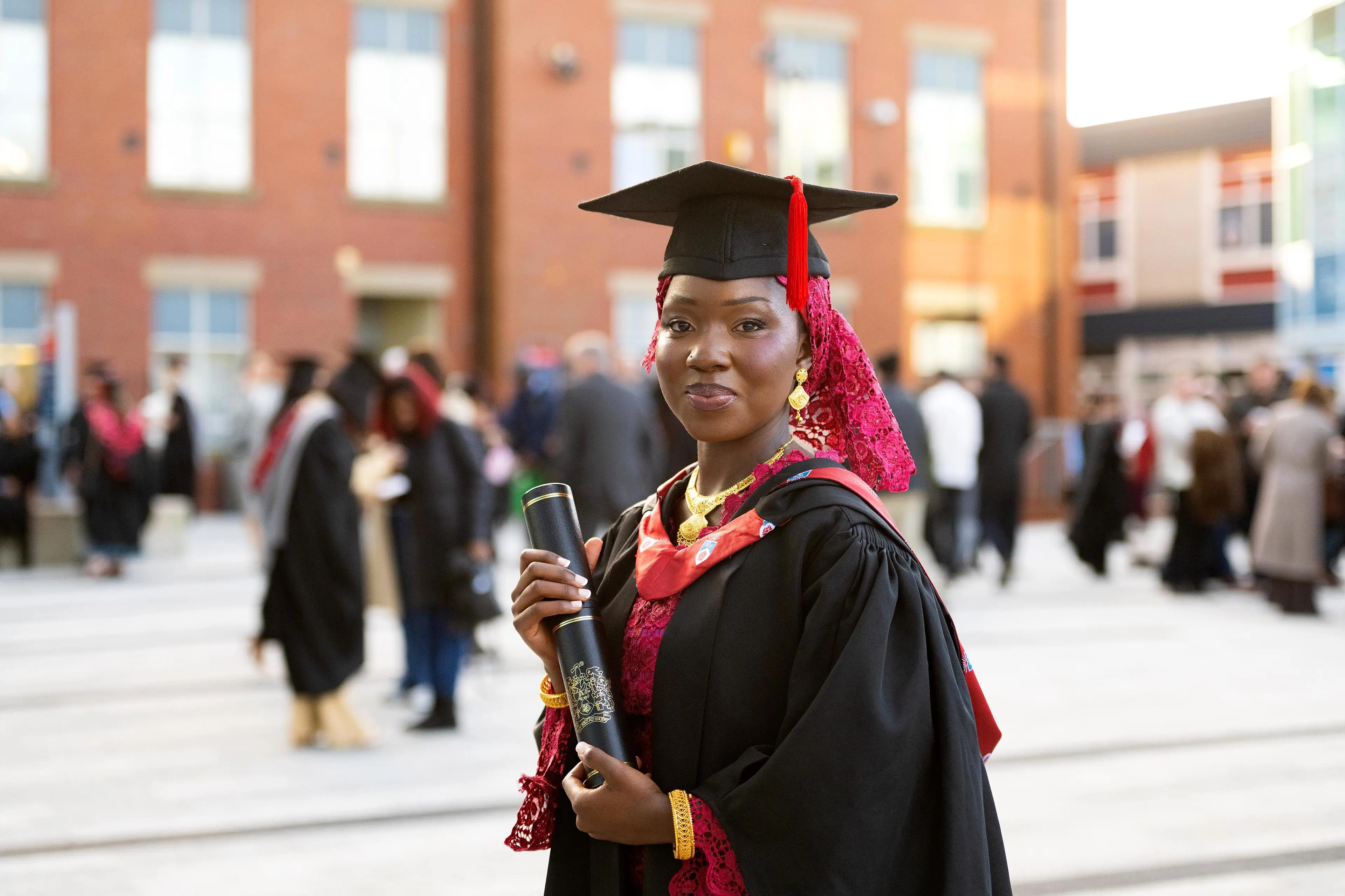 Salimatta Jabang wearing a cap and gown and holding a scroll