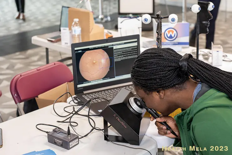 A woman examines an eye at the 2023 Preston Health Mela