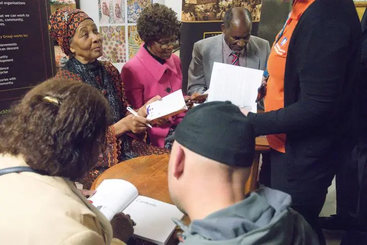 Interviewees Jane Wade and Bridgette and Sylius Toussaint sign copies of the book 