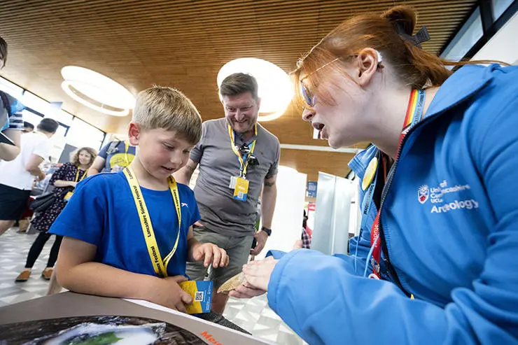 Alexander Dixon, 6, from Tarleton learns about stone age axes from UCLan archaeology student Aleksandra Cameron