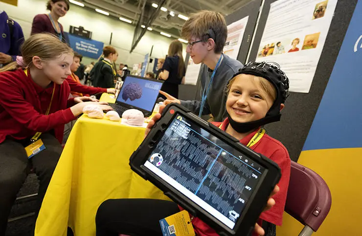 Amelia Charnley, 10, (left) and Milita Smigleskaite, 9, from Shadsworth Junior School see how brain waves work with UCLan student Gabriel Gibson.