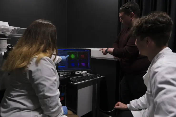 Monica Smithies, Dr Stéphane Berneau and Nathan Parks, examining slide results