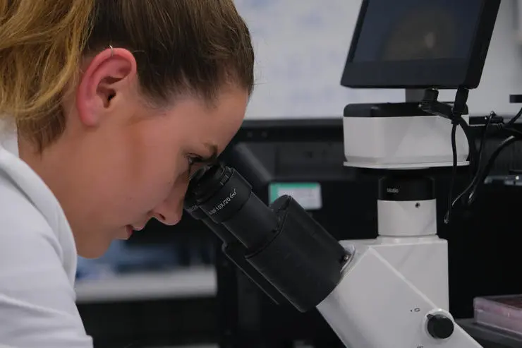 Monica Smithies, third year biology student, looking at slides under a microscope