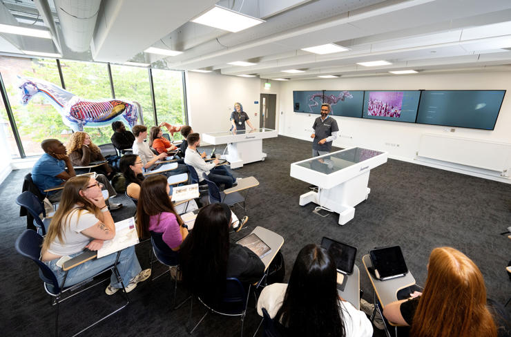 A teaching space featuring Anatomage tables and large screens