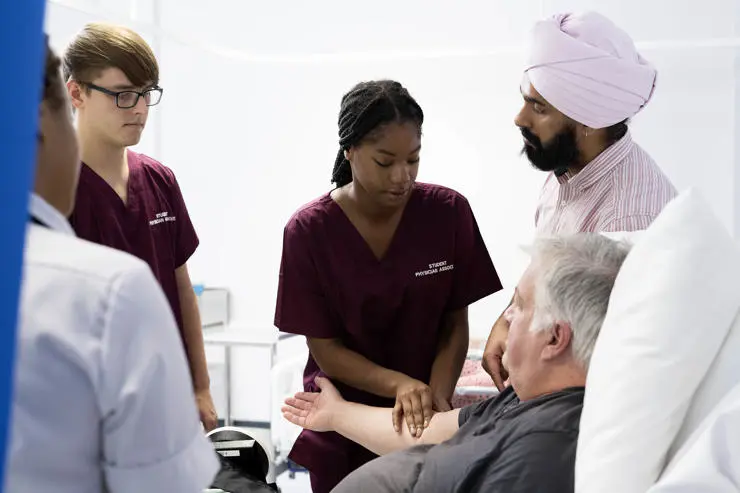 A physician associate trying to find a vein in a patient's arm