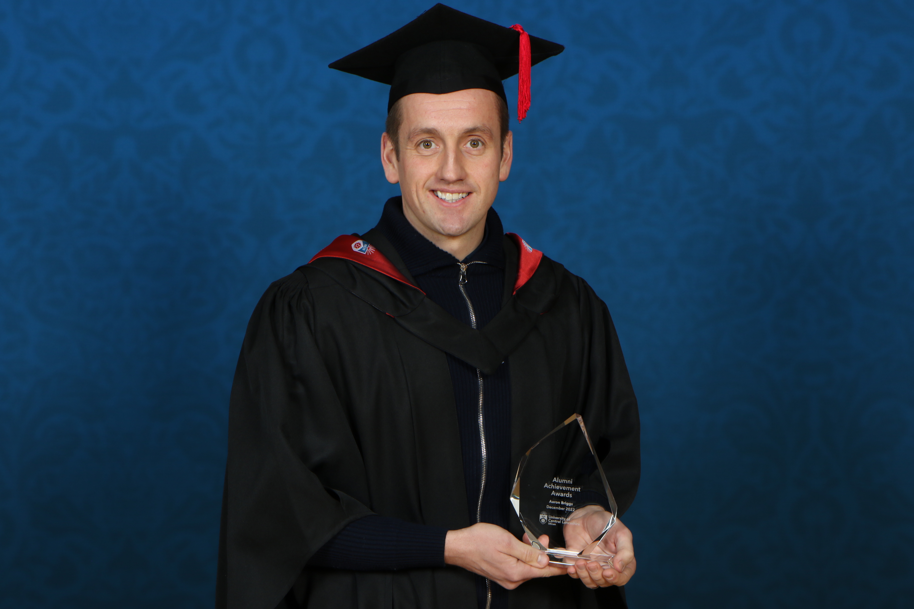 Aaron Briggs holding his Alumni Achievement Award