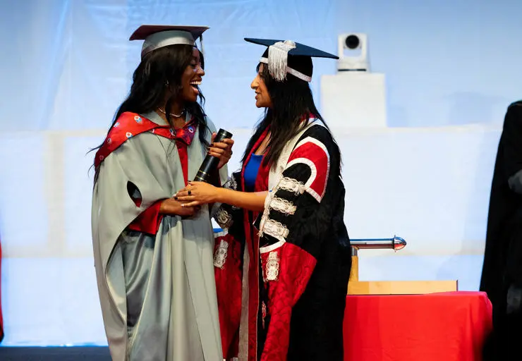UCLan Honorary Fellow AJ Odudu accepting her Honorary Fellowship from UCLan Chancellor Ranvir Singh