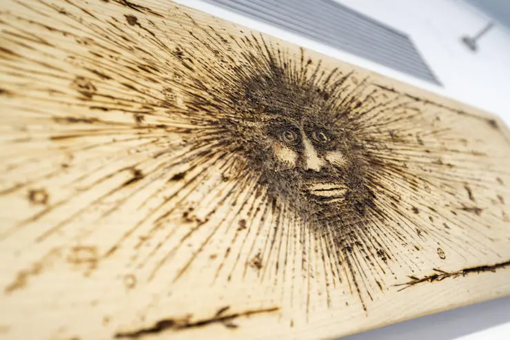 A striking face burnt on to wood, created by a service user
